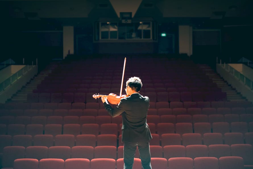 man-rehearses-for-event-on-stage-violin